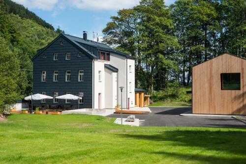 a black and white barn with a house at Apartmány Pstruží AP19 in Pstruží