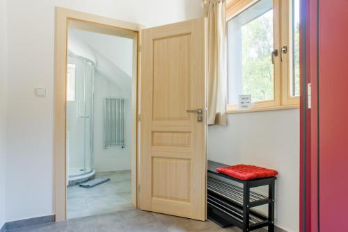 a bathroom with a wooden door and a window at Apartmány Pstruží AP19 in Pstruží
