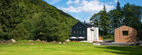 a black and white barn next to a grass field at Apartmány Pstruží AP19 in Pstruží