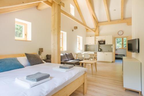 a living room with a large bed and a kitchen at Apartmány Pstruží AP19 in Pstruží