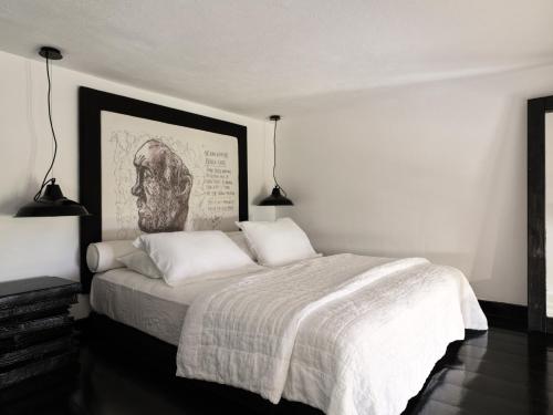 a bedroom with a bed with a drawing on the wall at Liostasi in Ios Chora