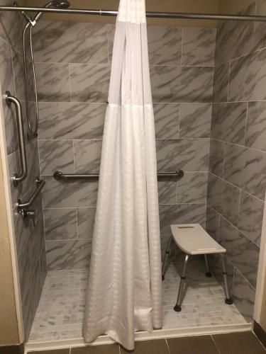 um chuveiro com uma cortina de chuveiro branca na casa de banho em Wingate by Wyndham Grove City em Grove City