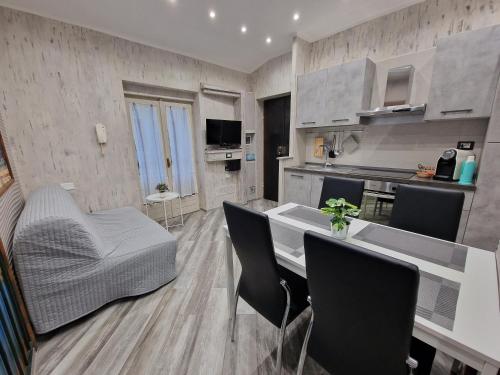 a kitchen and living room with a table and chairs at Appartamento in Piazza Vittorio Veneto con parcheggio, Torino in Turin