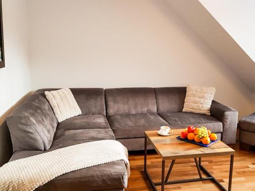a living room with a couch and a table with a bowl of fruit at Magiczny Karpacz Apartamenty w sercu natury in Karpacz