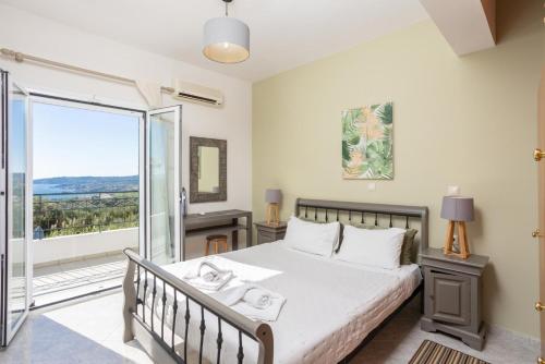 una camera con un grande letto e un balcone di Villa Erasmia a Vlachata