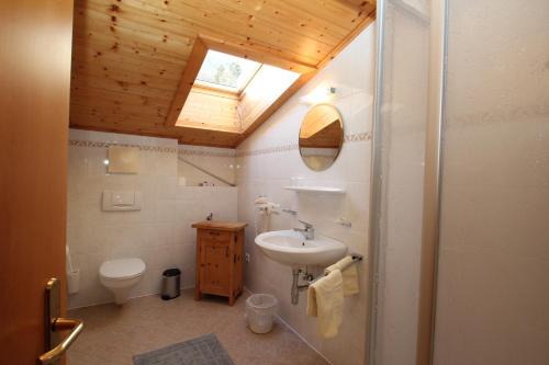 a bathroom with a sink and a toilet and a skylight at Obermooshof in Fügenberg