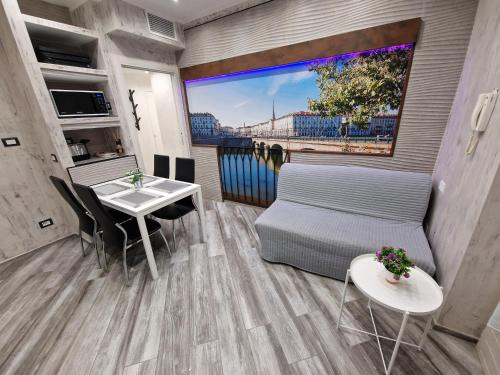 a living room with a bed and a table and a window at Appartamento in Piazza Vittorio Veneto con parcheggio, Torino in Turin