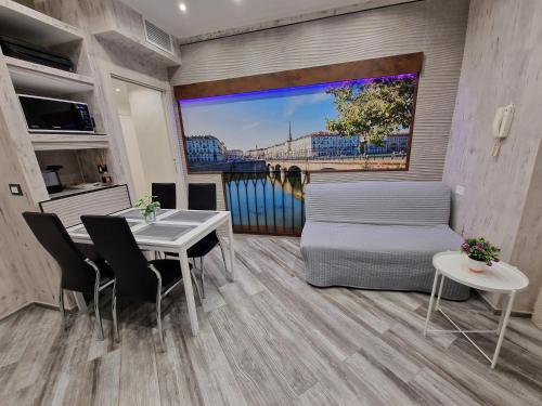 a living room with a table and chairs and a large window at Appartamento in Piazza Vittorio Veneto con parcheggio, Torino in Turin