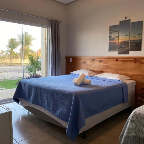 Pousada Delta Village في توتويا: غرفة نوم مع سرير وبطانية زرقاء