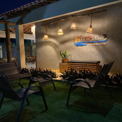 a patio with chairs and a sign on a wall at Pousada Delta Village in Tutóia