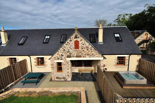a large house with a swimming pool in front of it at Rose Cottage at Williamscraig Holiday Cottages in Linlithgow