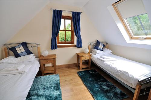 a room with two beds and a window at Rose Cottage at Williamscraig Holiday Cottages in Linlithgow