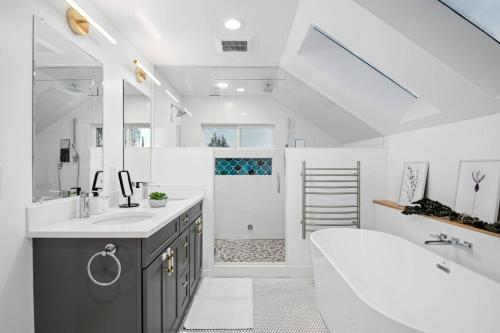 a white bathroom with a tub and a sink at Rhone Retreat in Portland