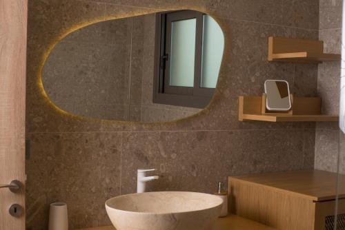 La salle de bains est pourvue d'un lavabo rond et d'un miroir. dans l'établissement Elaia Grove, à Kalamata