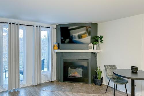 sala de estar con chimenea y TV encima. en Studio LIV204 by Gestion ELITE en Mont-Tremblant