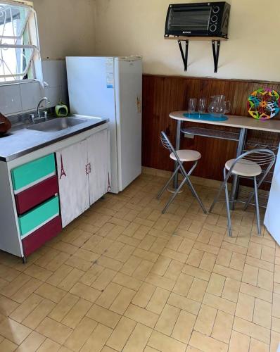 cocina con nevera, fregadero y mesa en Departamento con habitación, cocina y baño privado barrio la perla en Mar del Plata