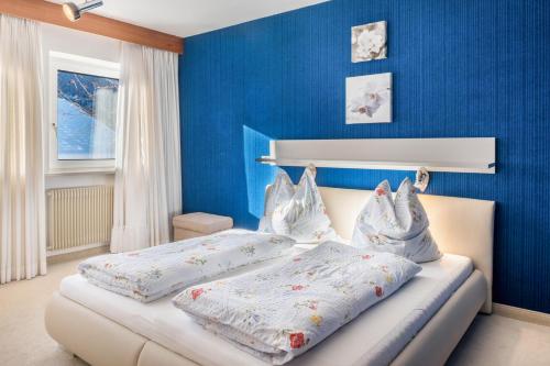 1 dormitorio con 2 camas y paredes azules en Sirena Carezza Apartment Regenbogen, en Carezza al Lago
