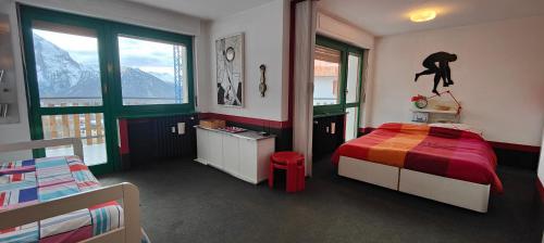 a bedroom with a bed with a red comforter at Hostdomus - Modern Art Flat in Sestriere