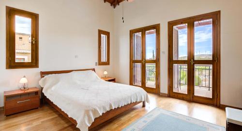 um quarto com uma cama e duas janelas em 2 bedroom Villa Oleander with private pool and garden, Aphrodite Hills Resort em Kouklia