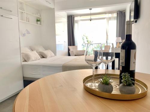 a bottle of wine and glasses on a table in a living room at Apartamento Loft-Suite in Platja d'Aro
