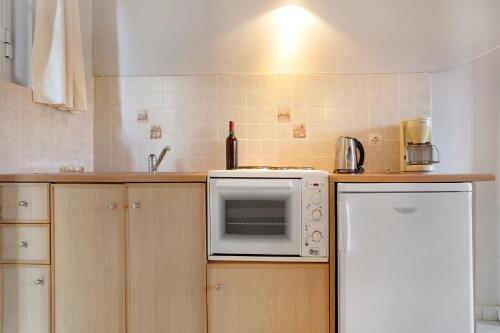 a kitchen with a white microwave and a refrigerator at Dolphin Studio 3 in Keri