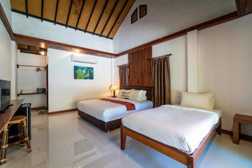 um quarto com 2 camas e uma secretária. em Chunut House Resort em Phi Phi Don