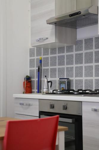 a kitchen with a stove and a red chair at Rocca dei tramonti in Punta Braccetto