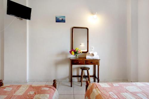 a bedroom with a table with a mirror and a stool at Dolphin Studio Sea View 11 in Keri
