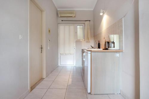 a white kitchen with a counter and a refrigerator at Dolphin Studio Sea View 11 in Keri