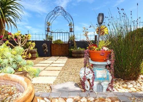 a garden with a gate and a vase in a yard at Le Mahi Guest House in Langebaan