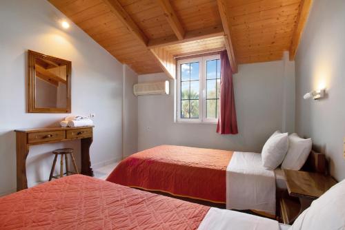 una camera d'albergo con due letti e una finestra di Dolphin Apartment Sea View 12 a Keríon