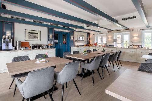 a dining room with wooden tables and chairs at Nordsee-Hotel Arlau-Schleuse in Husum