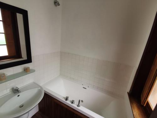 a bathroom with a white tub and a sink at Hotel La Résidence Manoir De La Salamandre in Étretat