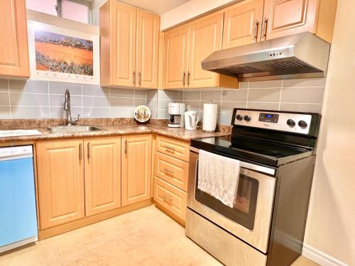 a kitchen with wooden cabinets and a stove top oven at Cozy Home in Richmond Hill with Free Parking in Richmond Hill
