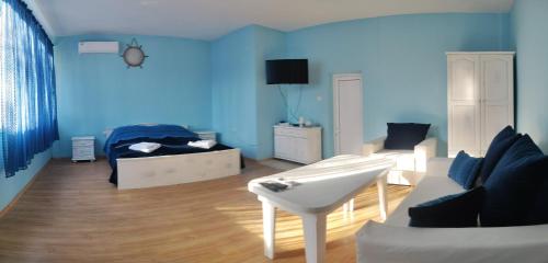 a blue living room with a couch and a bed at Хотел Тримата мускетари in Varna City