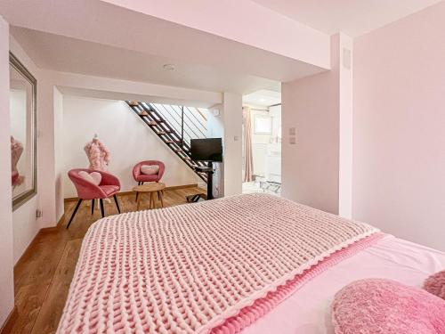 Villeneuve-de-la-Raho的住宿－Splendide Suite LOVE ROOM avec JACUZZI PRIVATIF，一间卧室配有粉红色的床和两张粉红色的椅子