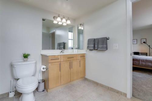 a bathroom with a toilet and a sink and a mirror at Splendid 2 BR Condo At Pentagon City in Arlington