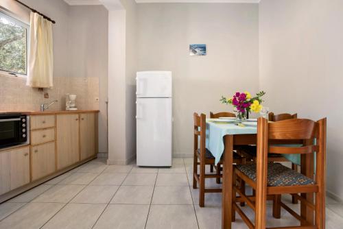 a kitchen with a table and a white refrigerator at Dolphin Apartment 8 in Keri