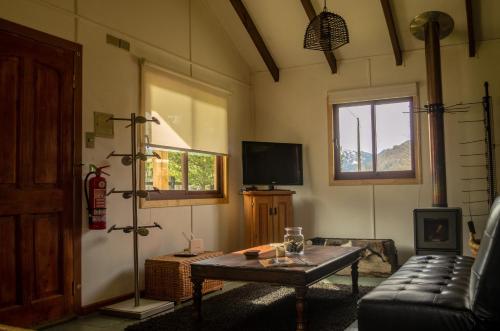 a living room with a couch and a table at Refugio Simple Sur Casa 6 personas in Malalcahuello