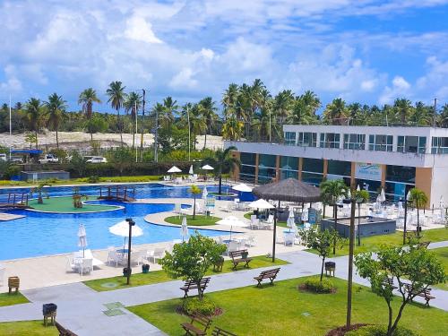 a resort with a large pool and a building at Muro Alto Condomínio Clube in Porto De Galinhas