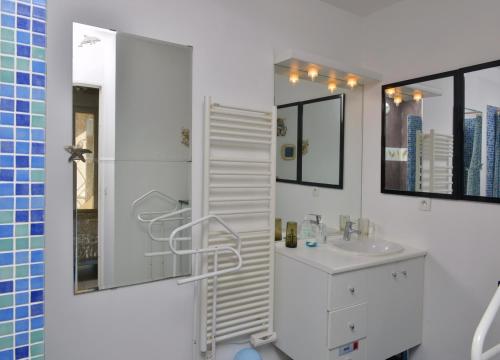 La salle de bains blanche est pourvue d'un lavabo blanc et d'une douche. dans l'établissement Jardin D'Azur proche mer, à Cagnes-sur-Mer