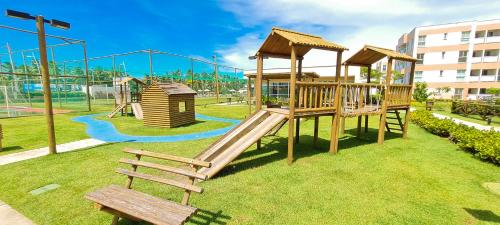 um parque infantil com escorrega e um banco num parque em Muro Alto Condomínio Clube em Porto de Galinhas