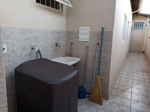 a bathroom with a sink with a tarp on the wall at Quarto Hokkaido na Sakura House in Indaiatuba