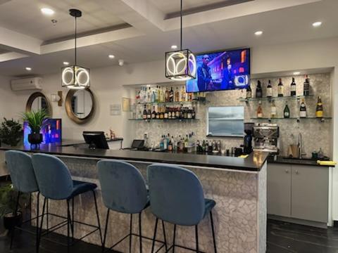 a bar with blue chairs and a counter with drinks at Days Inn by Wyndham Montreal East in Montreal
