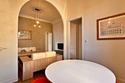 - un salon avec une table blanche et un miroir dans l'établissement Au Petit Bourgeois, à Nice