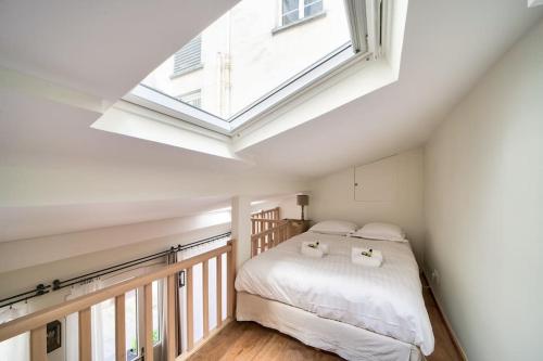 um quarto com uma cama e uma clarabóia em Superbe maisonnette neuve au coeur de Paris em Paris