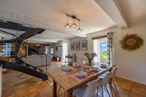 une salle à manger avec une table et un escalier dans l'établissement Ty-Voli - Magnifique Longère rénovée, à Plougoumelen