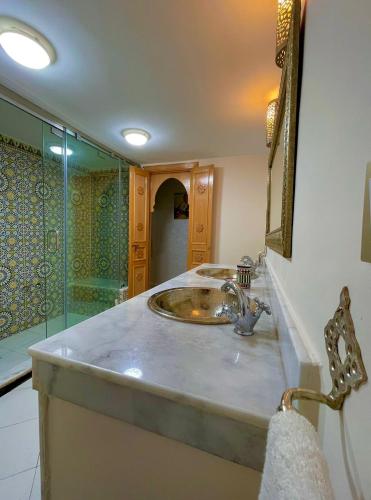 een badkamer met een wastafel en een douche bij Stay In Fez in Fès