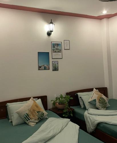two beds sitting next to each other in a room at Nhà nghỉ Phương Dung in Phu Quoc