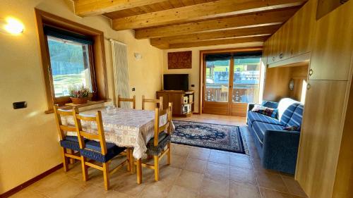 uma cozinha e sala de jantar com mesa e cadeiras em Sarochin Appartamenti em Livigno
